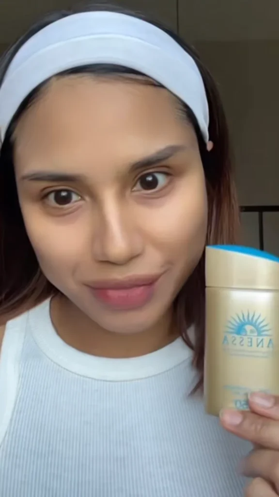 Influencer holding Anessa SPF50+ sunscreen outdoors with on-screen text reading 'No.1 Japan Sunscreen from Shiseido Group'