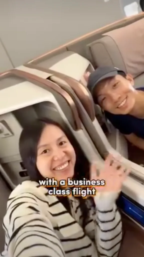 Couple smiling on a business class flight, captioned 'with a business class flight