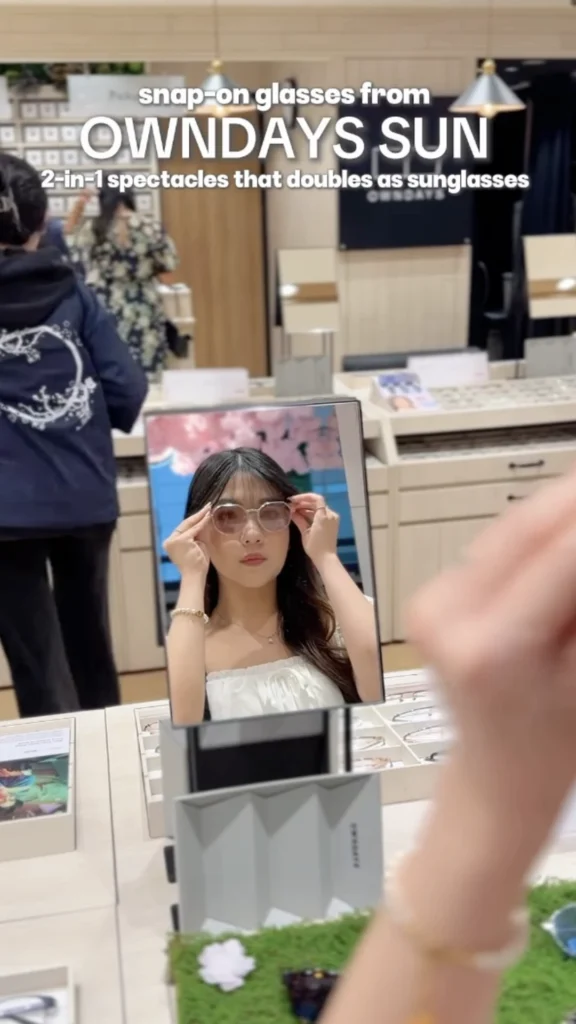 Woman trying on Owndays Sun snap-on glasses that convert to sunglasses, in-store product demo for Owndays influencer campaign