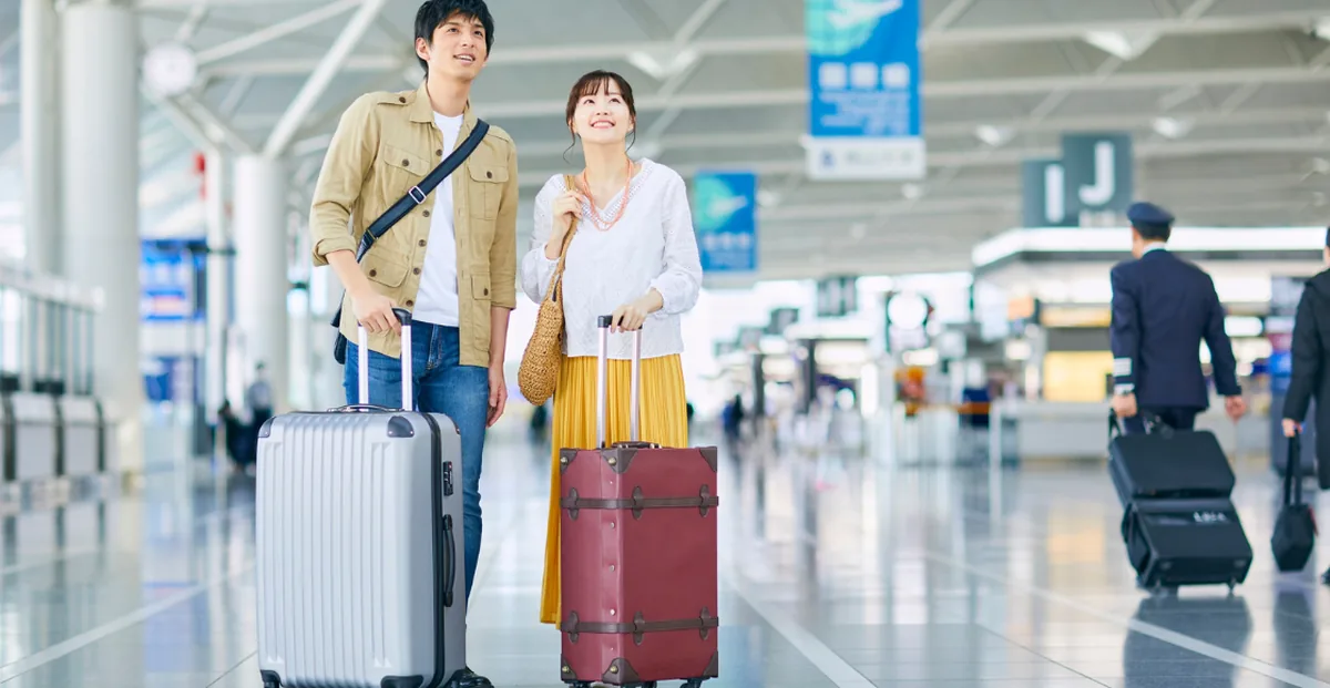 Couple traveling with luggage at the airport, featured in the Income influencer marketing case study